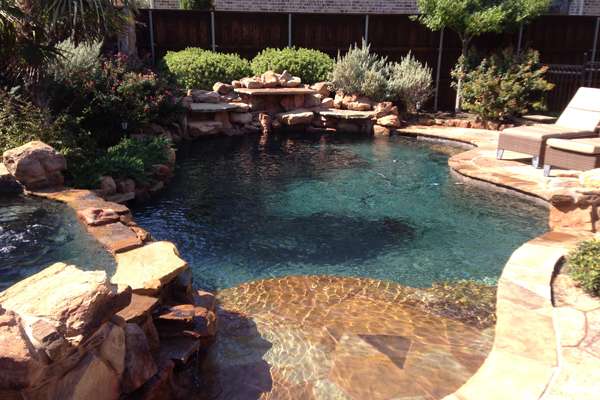 Man cleans fall leaves from pool