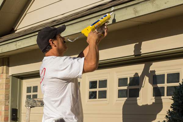 caulking gutter with caulk gun