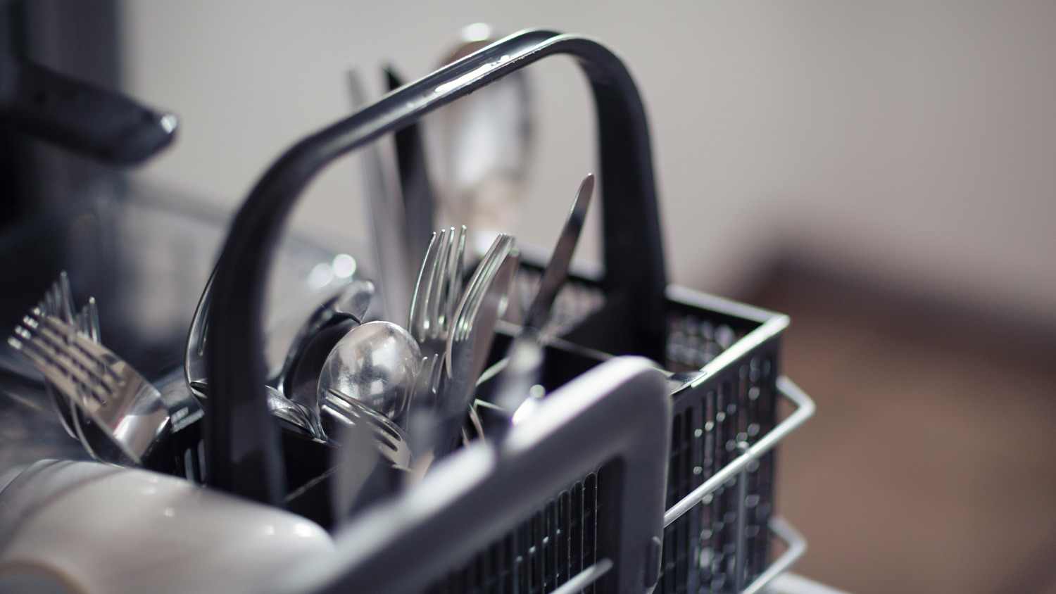 Close-up of cutlery placed in a dishwasher