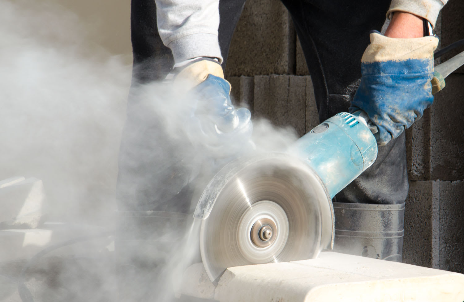A worker cutting stone with a grinder