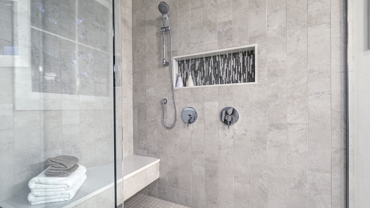 Glass walk-in shower with tiled niche