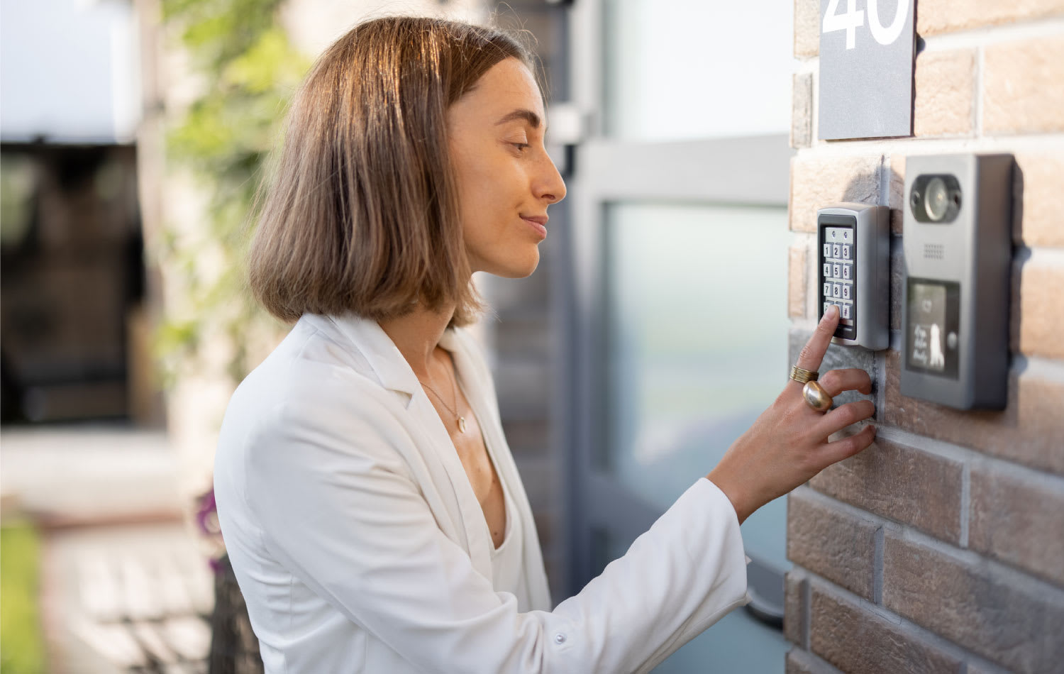 A woman entering a code on a keyboard to access a door