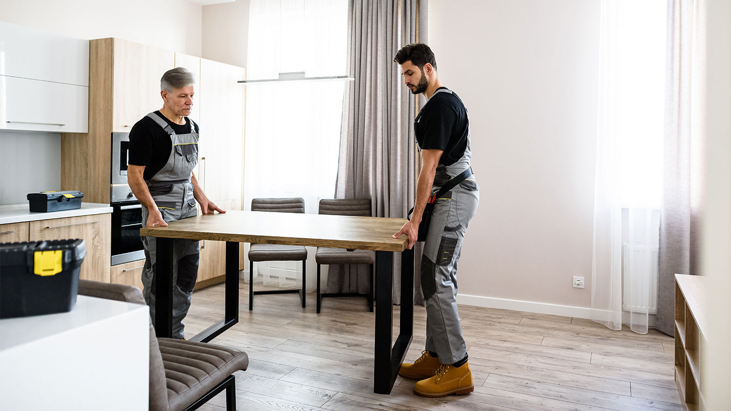 Two workers moving dining table