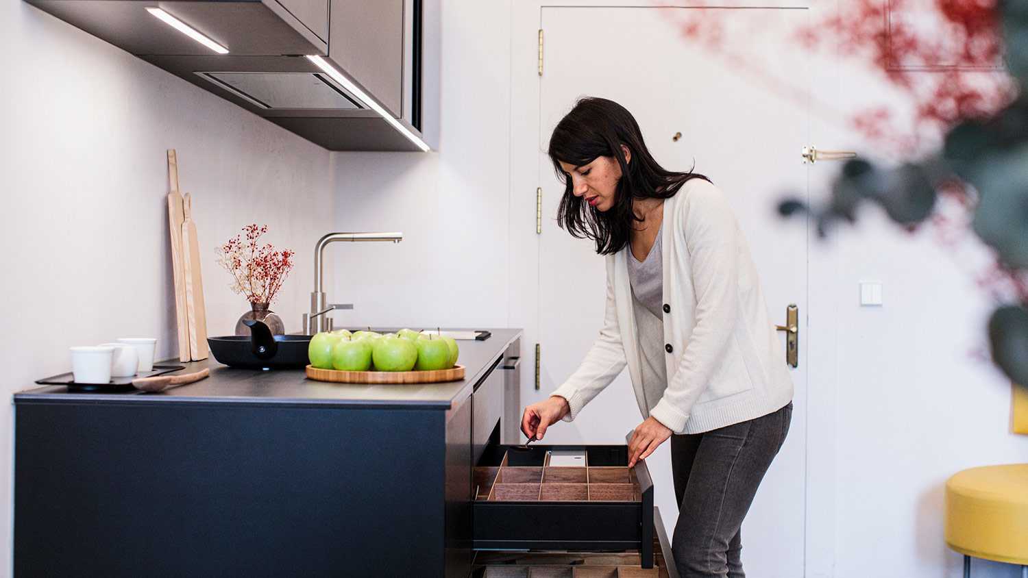 Woman opening drawers in kitchen