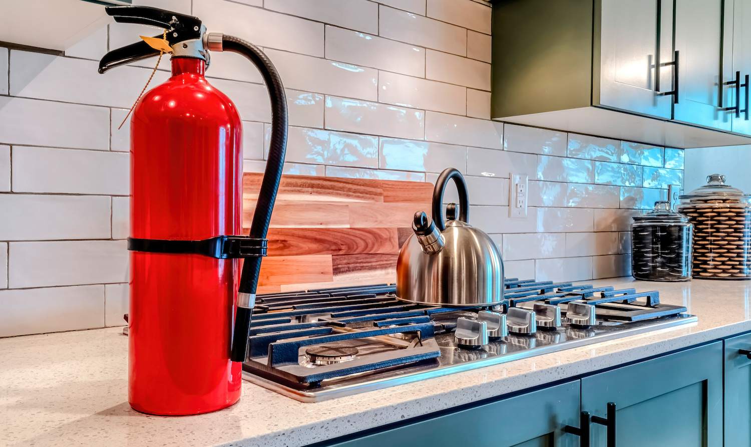 a red fire extinguisher on kitchen counter in bright, modern kitchen