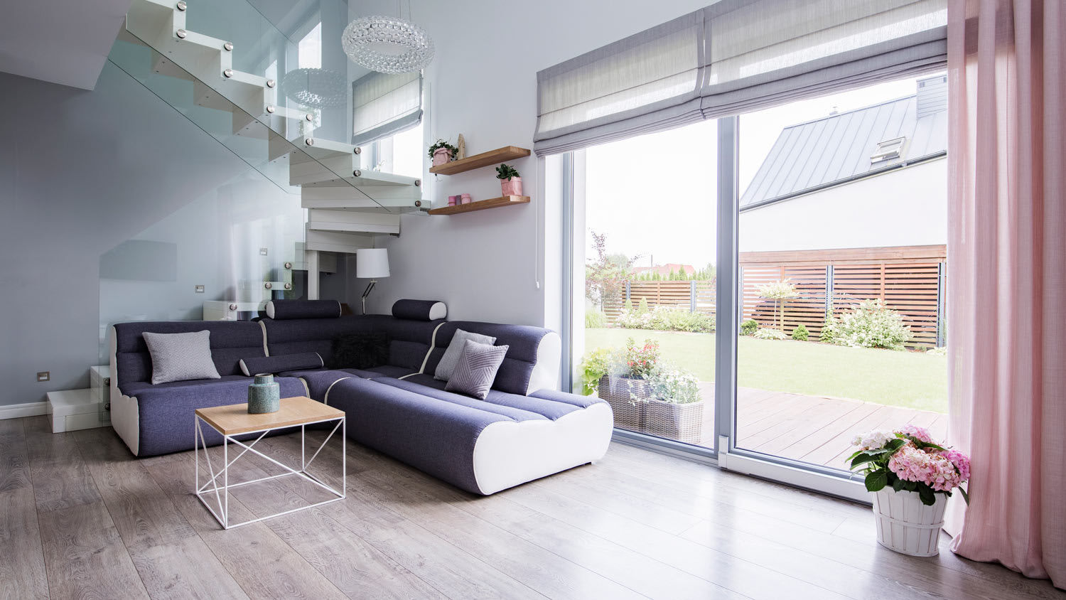 A living room with tall windows with roman shades