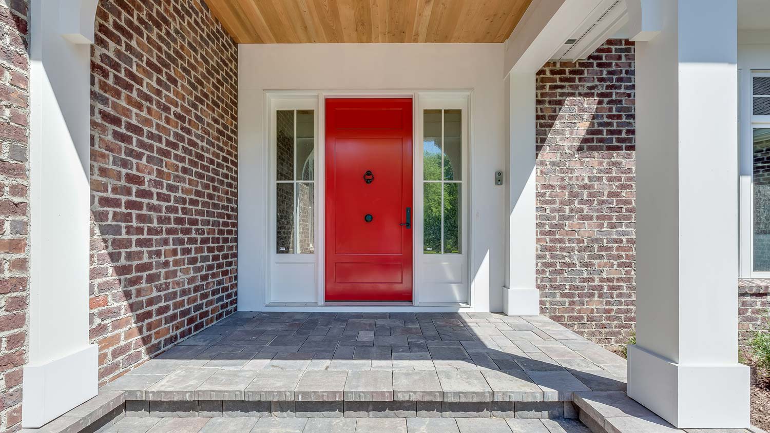 A stone porch leading to a red front door