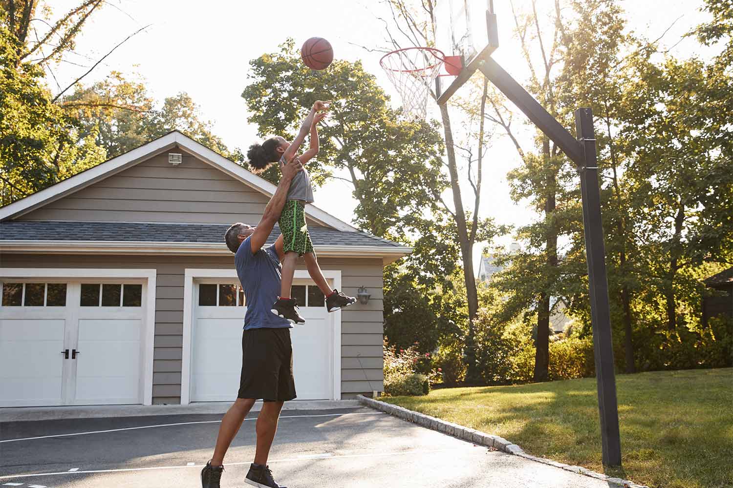 father plays basketball with son at home