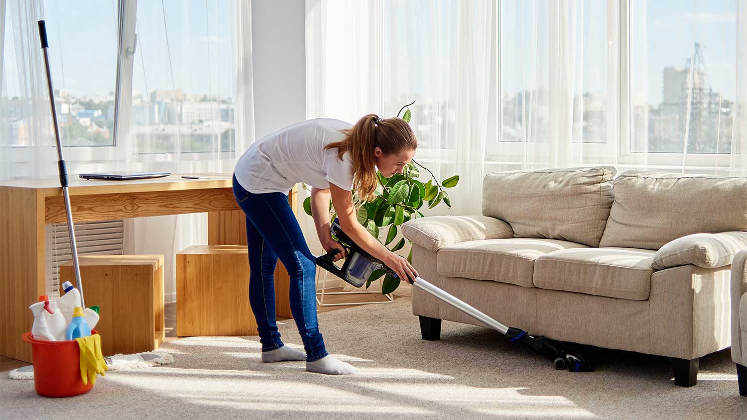 Woman vacuuming and cleaning living room