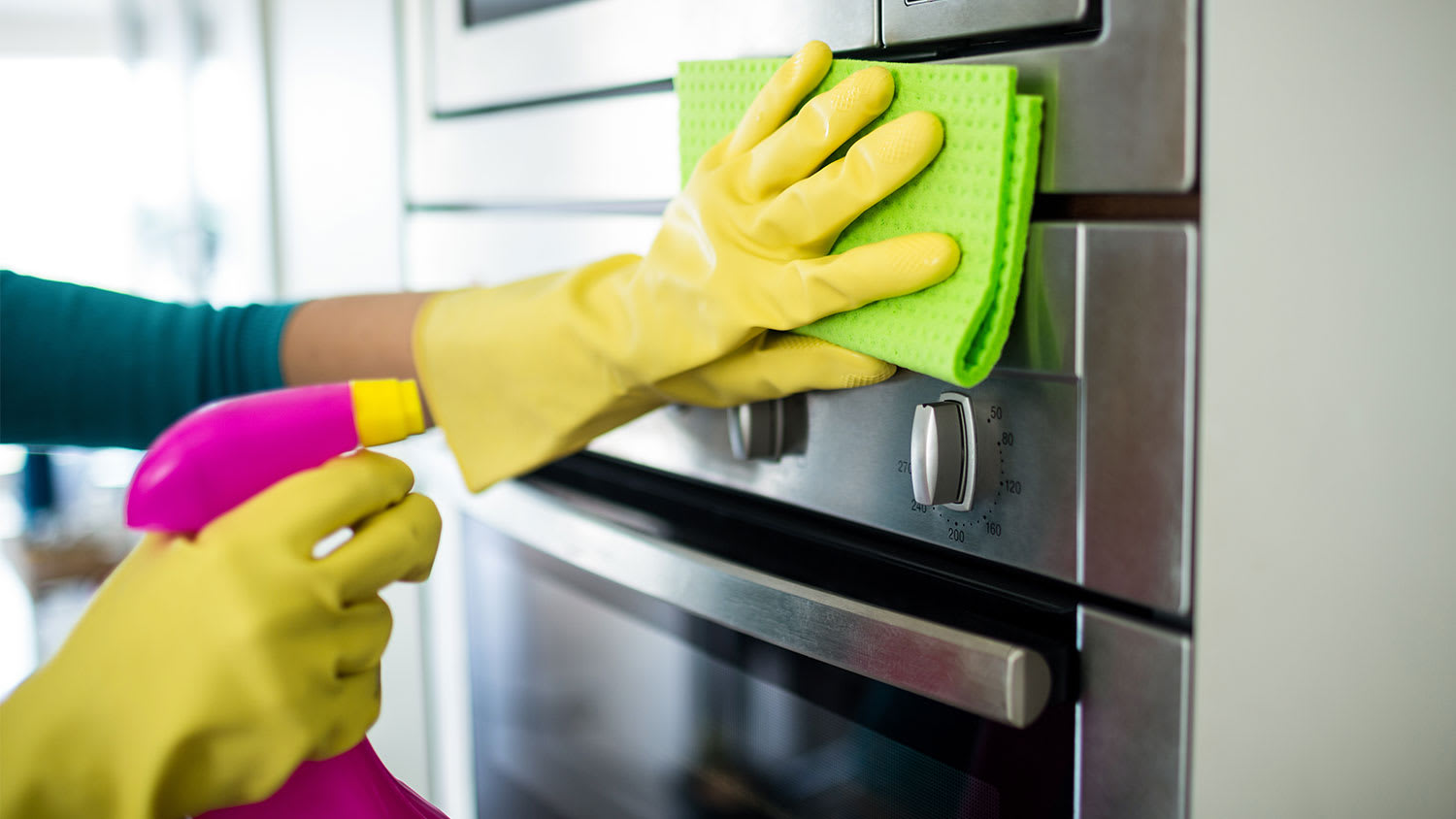 WOMAN CLEANING OVEN