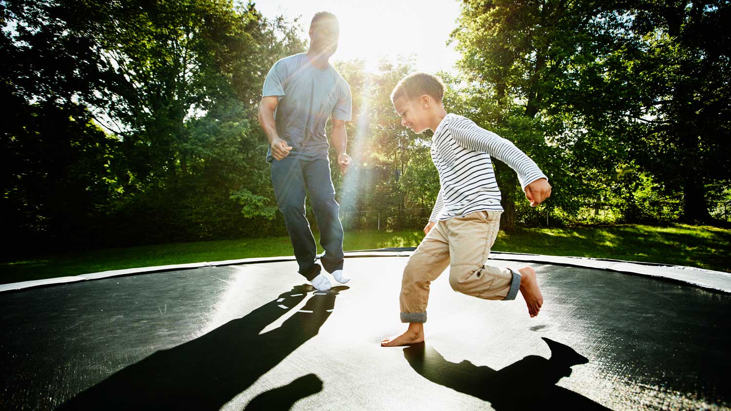 A father with his son playing on a trampoline