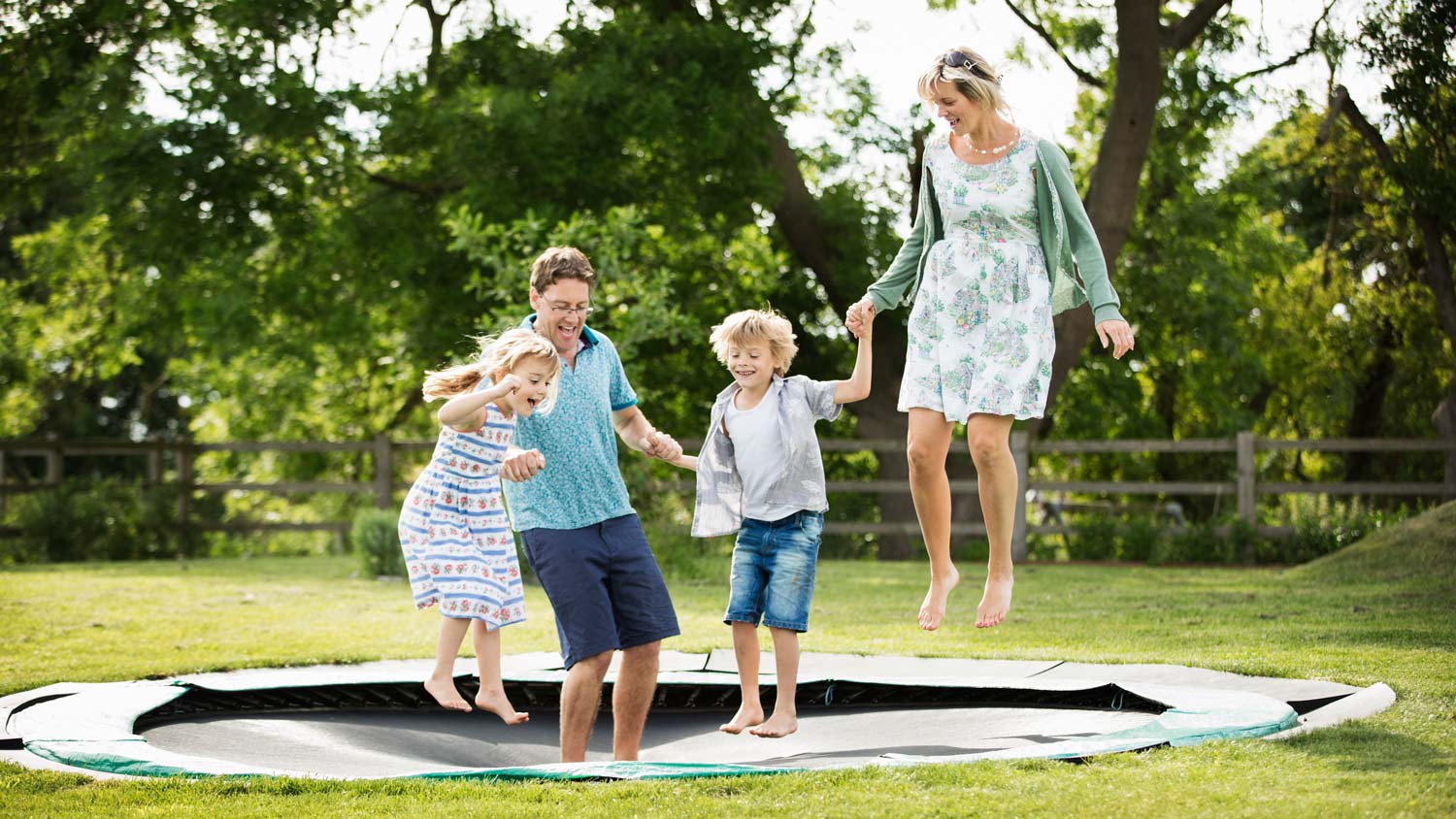 A family jumping altogether on the trampoline