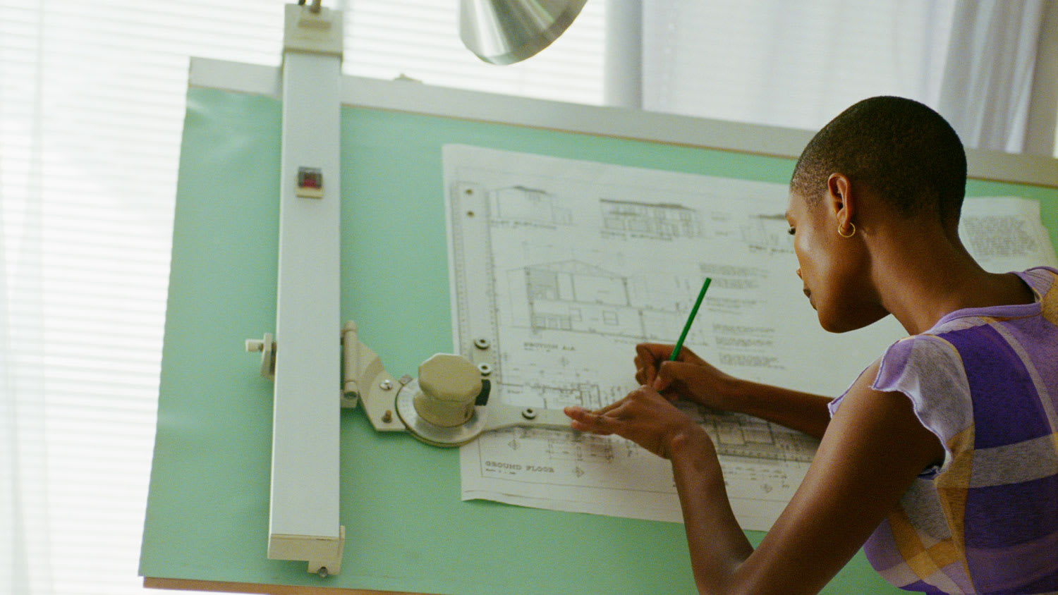 An architect sketching on a drafting table