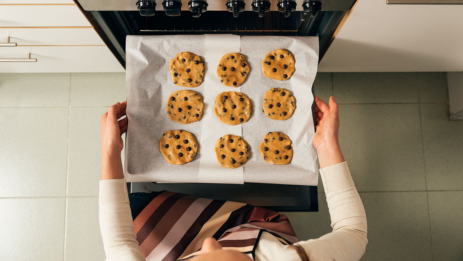 Topview of a woman baking cookies in oven