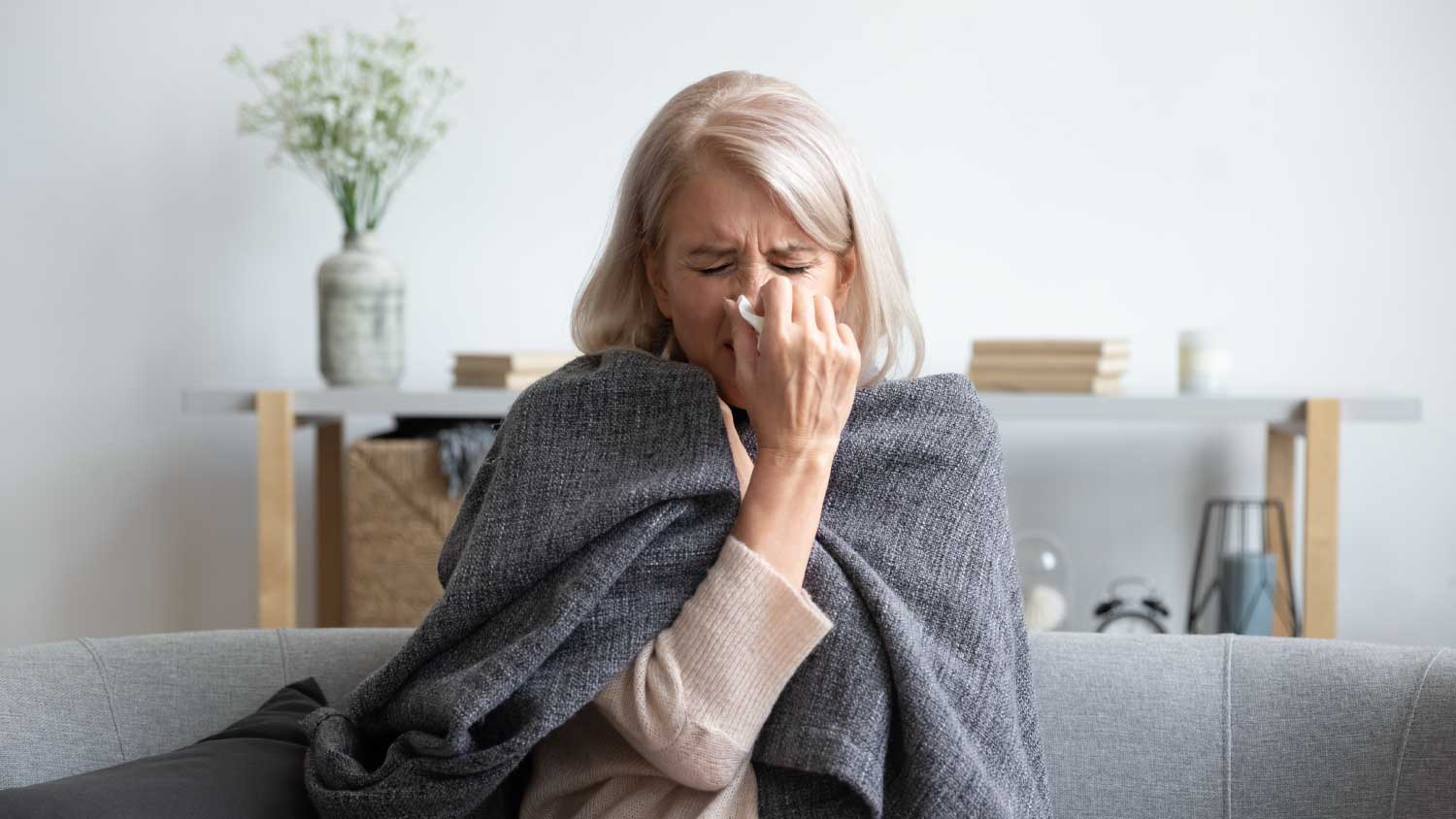Woman sneezing in home