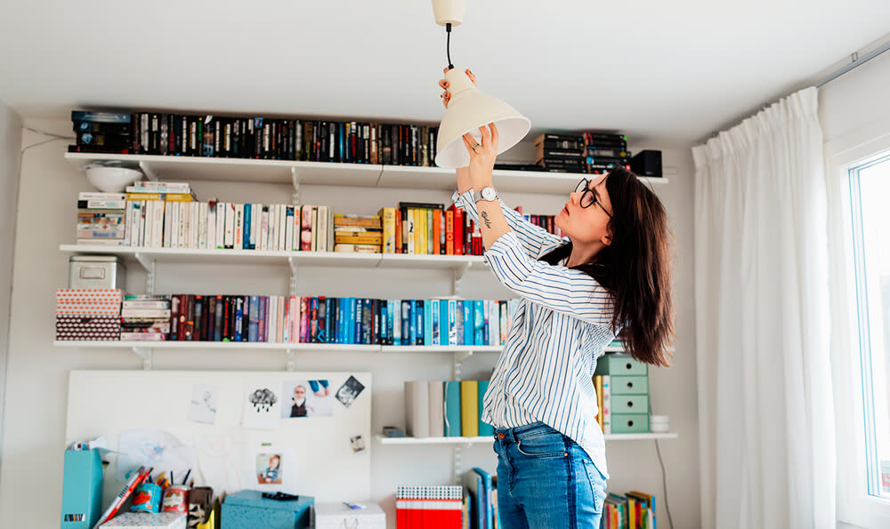 Person changing a lightbulb in a home office