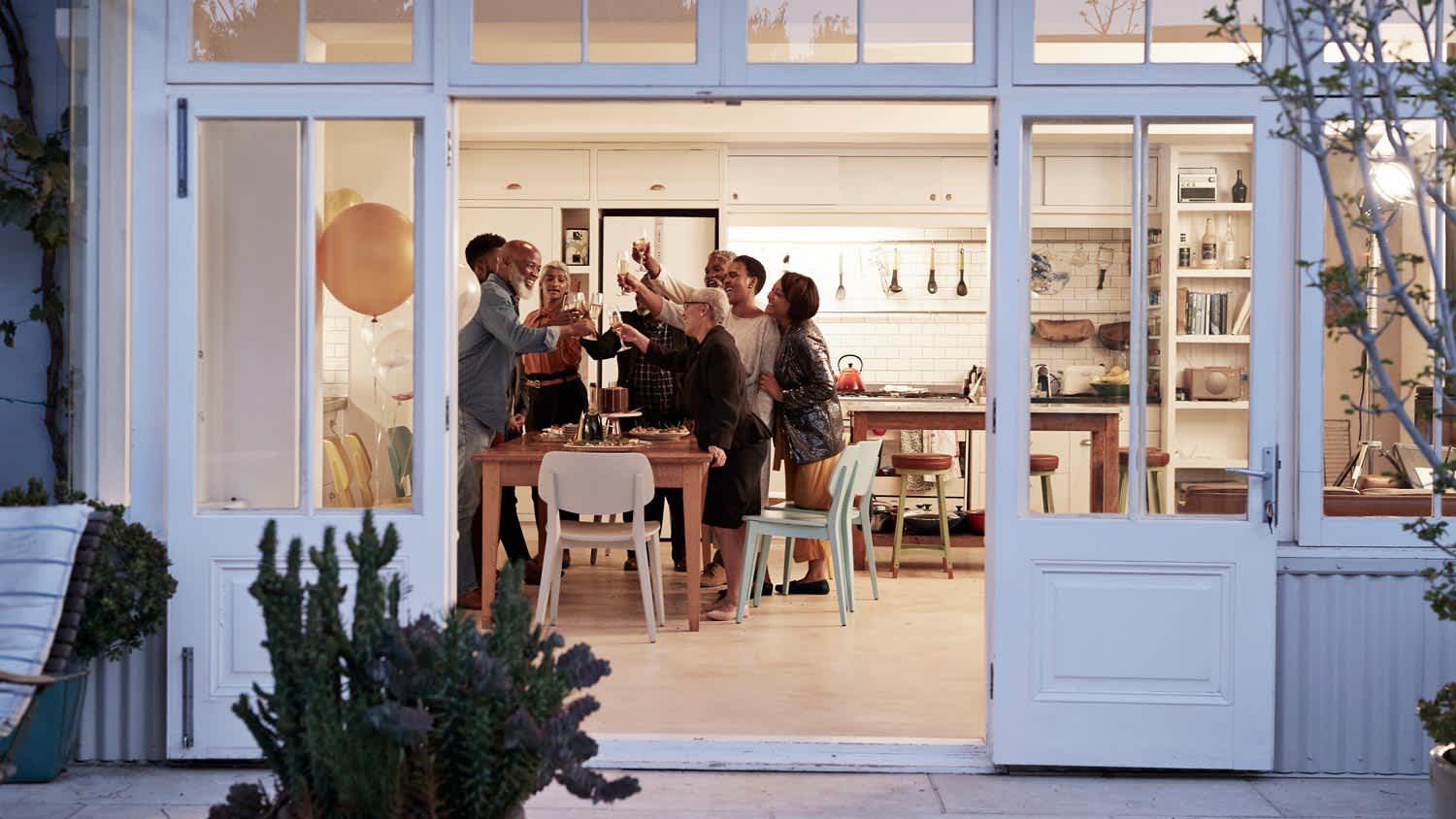 A family toasting at a birthday dinner in an open-plan kitchen