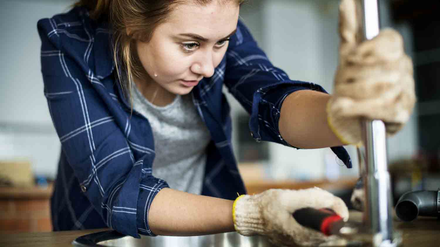 woman fixing kitchen sink