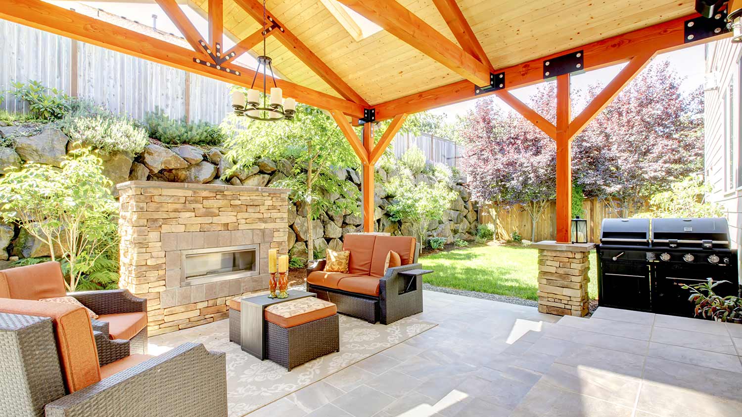 Exterior covered patio with fireplace and furniture