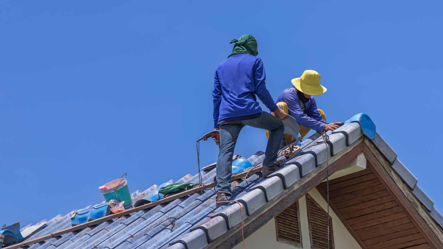 Worker repairing leaking ridges tiles