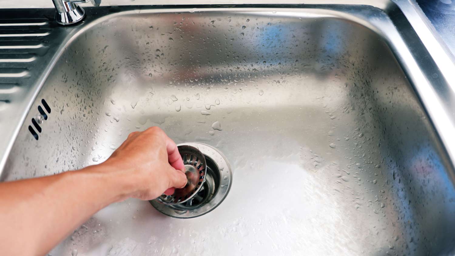 person putting lid on drain hole