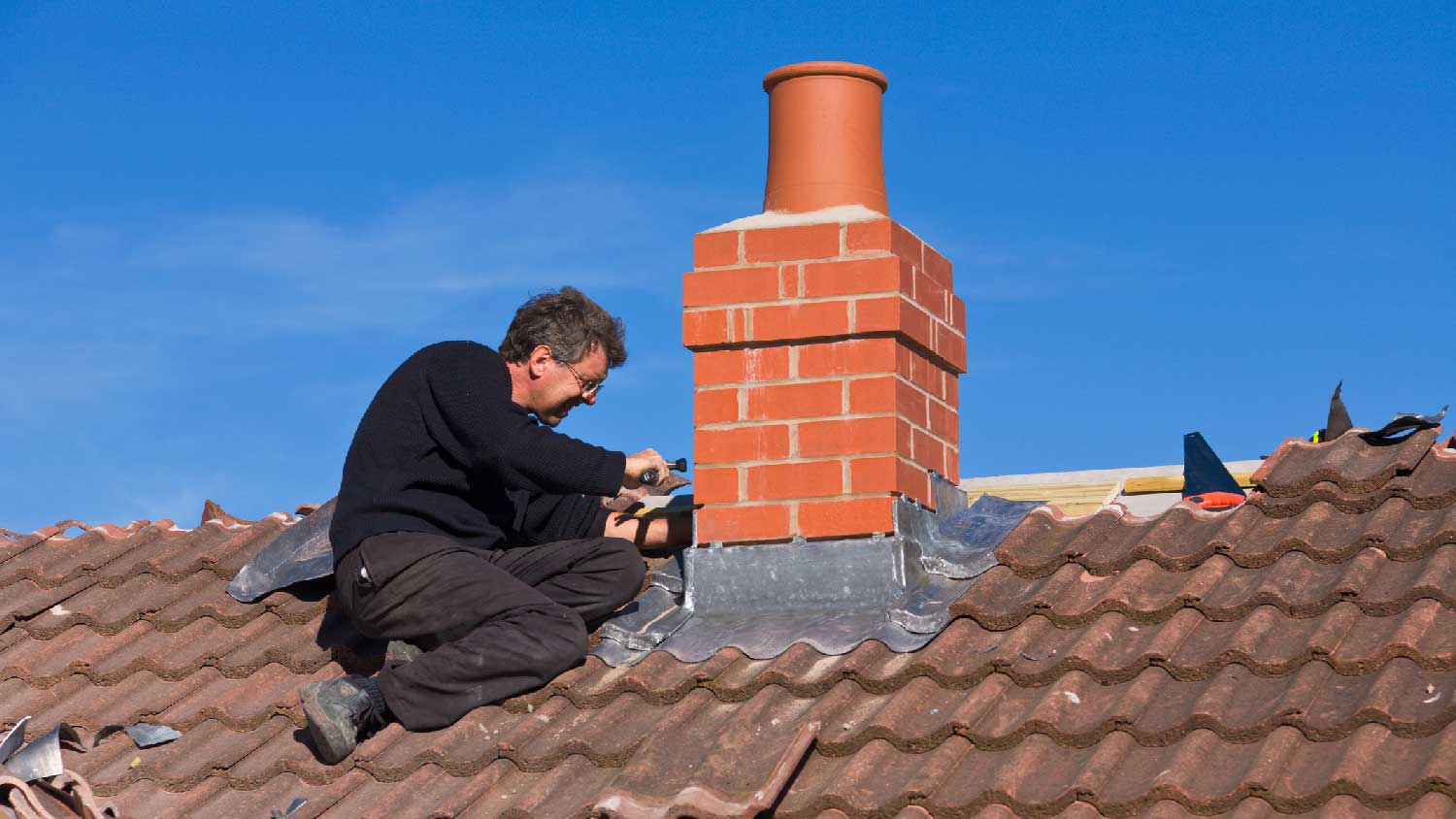 None A person inspecting for a chimney leakage
