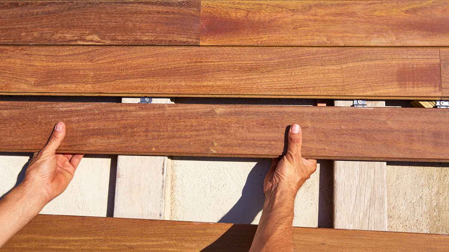 Carpenter installing ipe wood boards on a deck