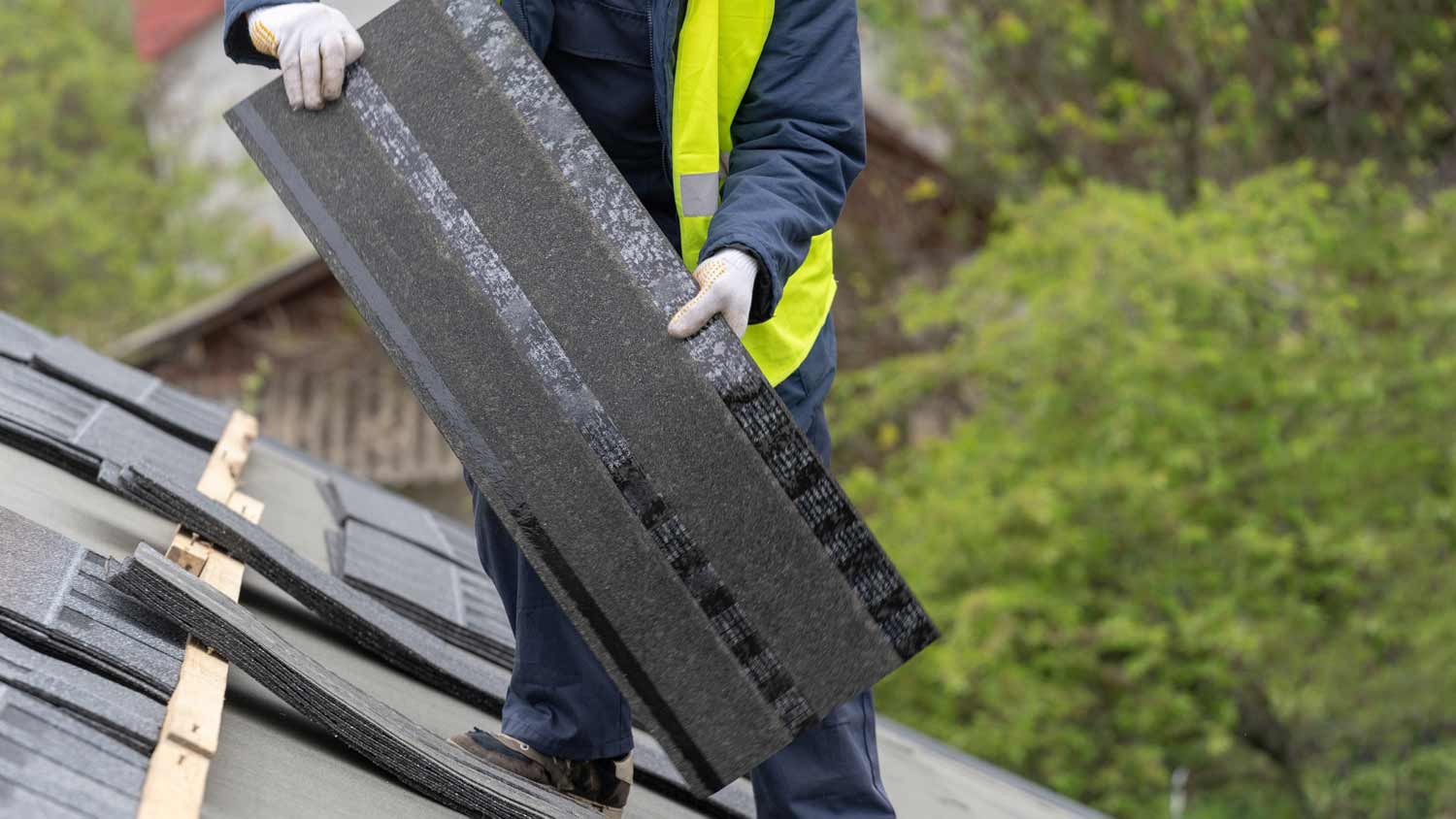man carrying roof shingle
