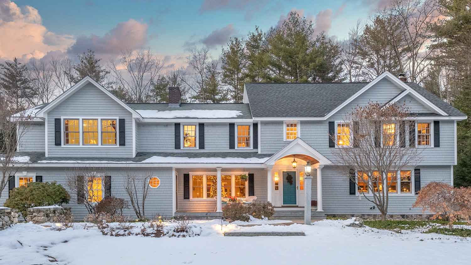 Large house in the winter surrounded by trees