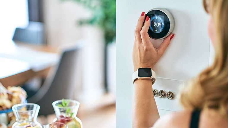 None Woman adjusts air-conditioner’s temperature via a digital thermostat