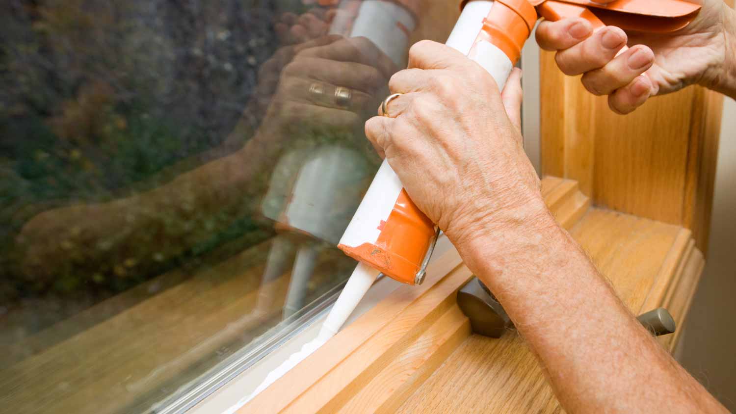 None Man applying weather seal caulk