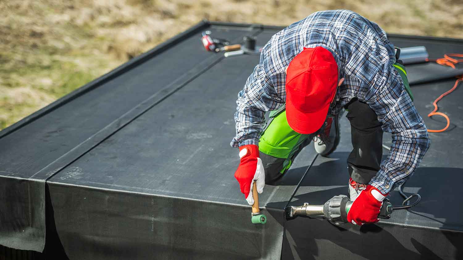 Worker installing epdm membrane on a flat roof