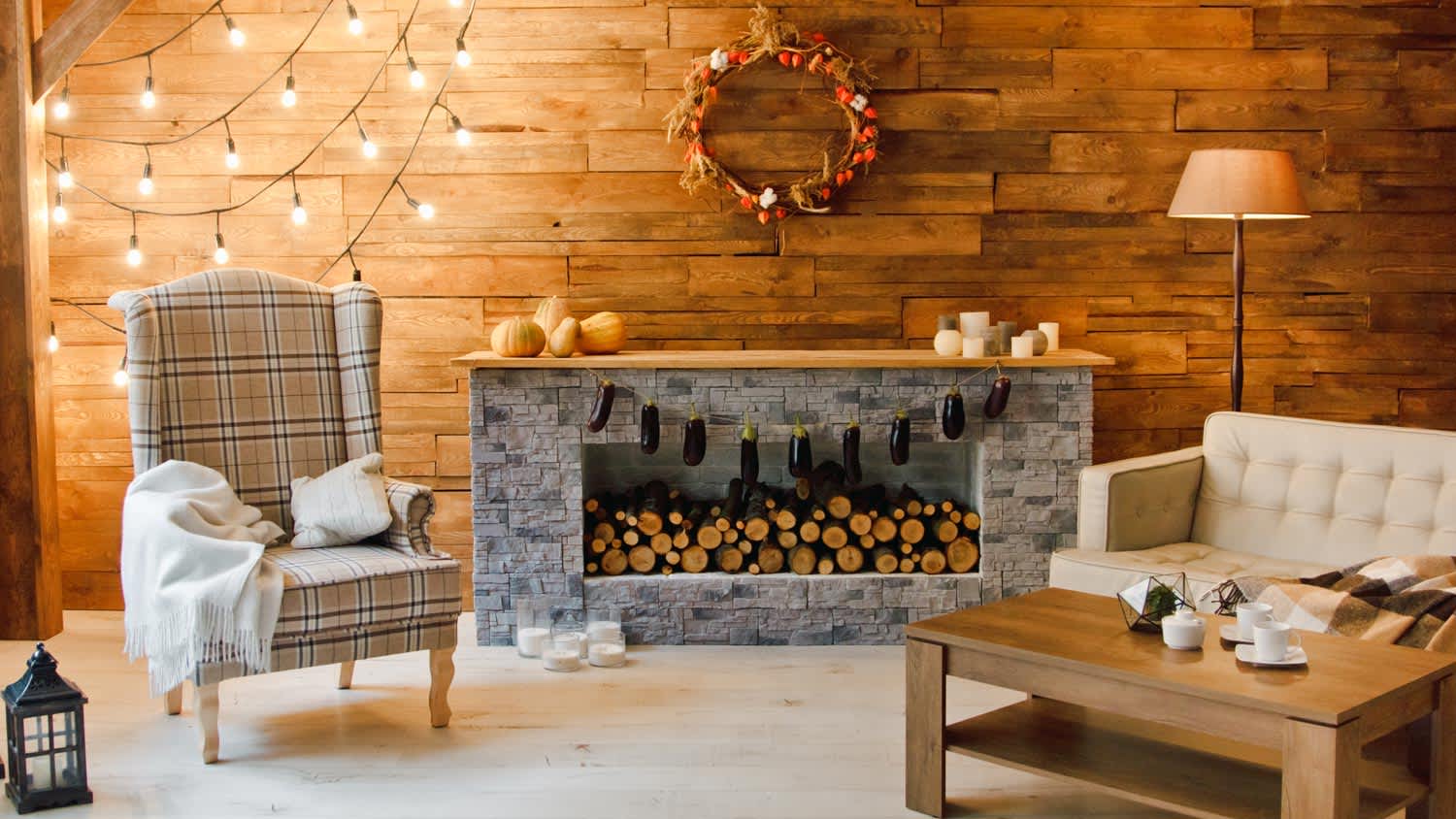A Christmas decorated room with wooden wall and a wreath above the fireplace