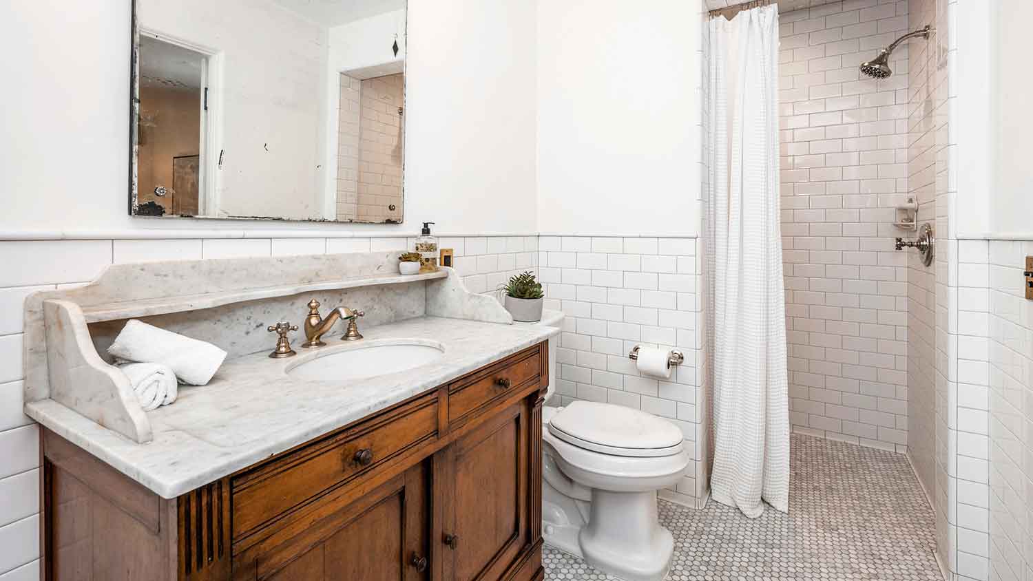 Bathroom with stone vanity top over a wooden cabinet