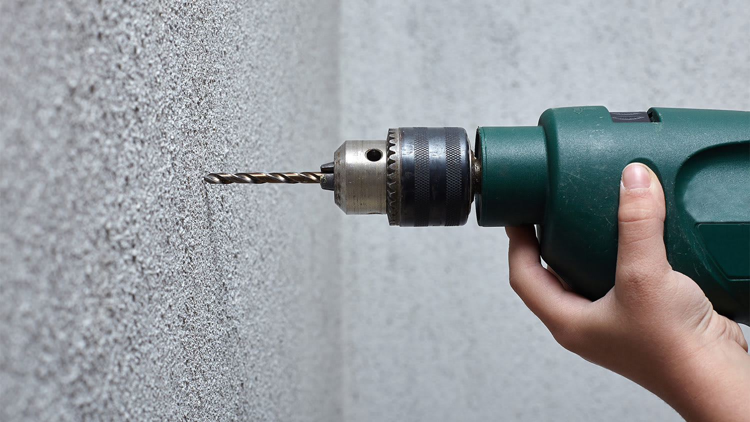 None Cropped hand of person holding equipment against wall