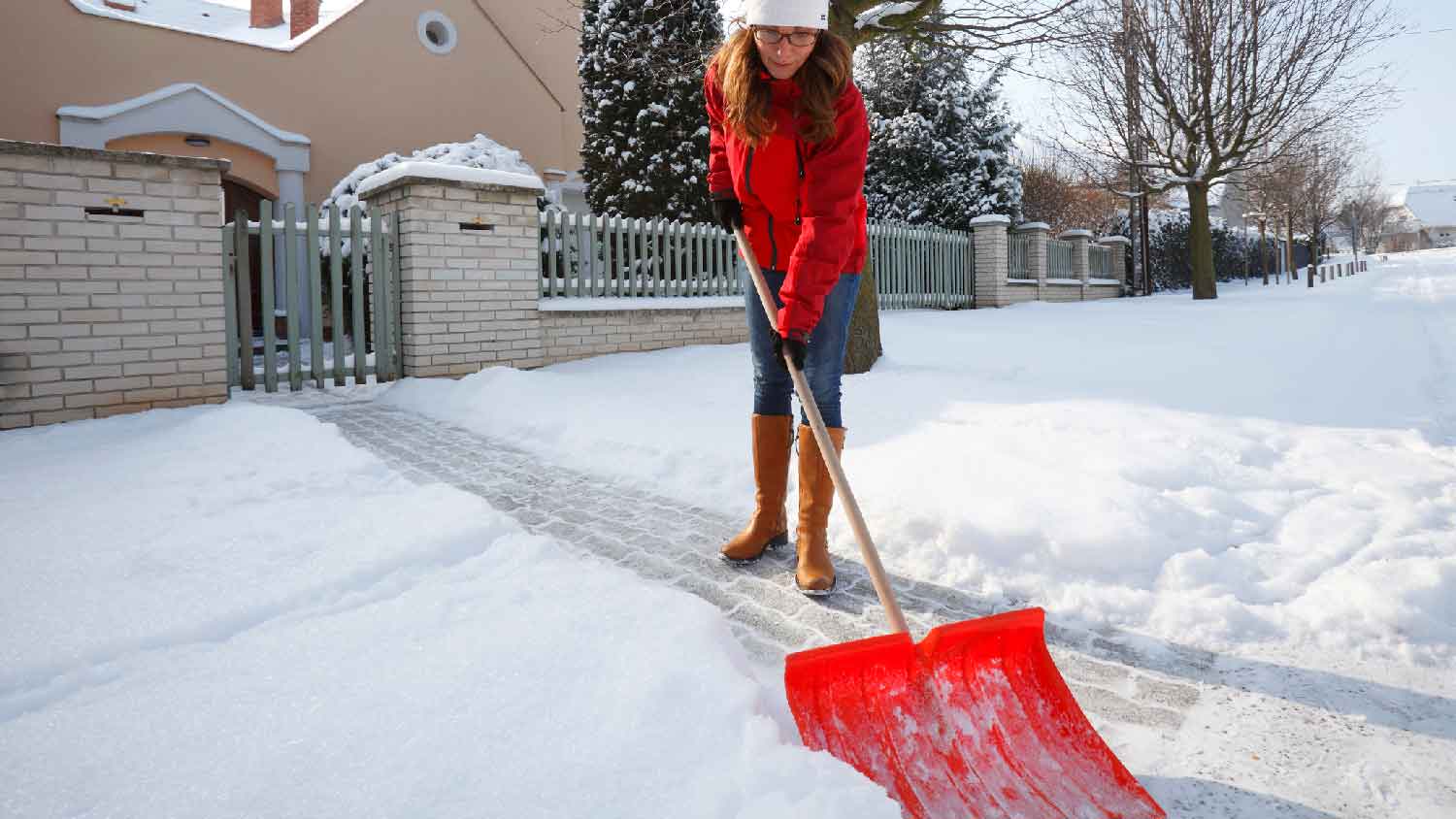 A woman shovelling snow