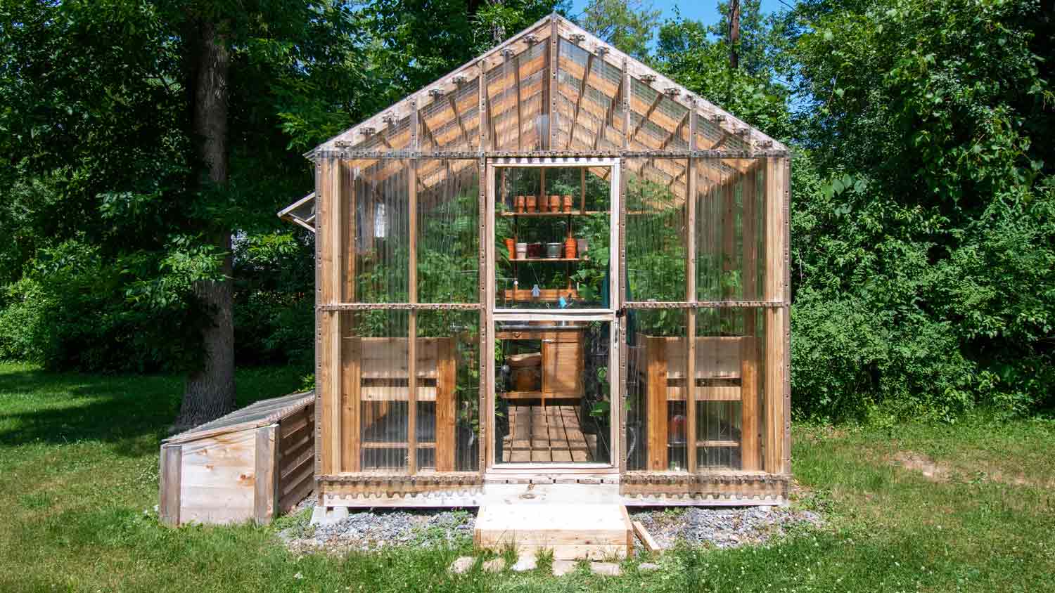 None wooden greenhouse in yard