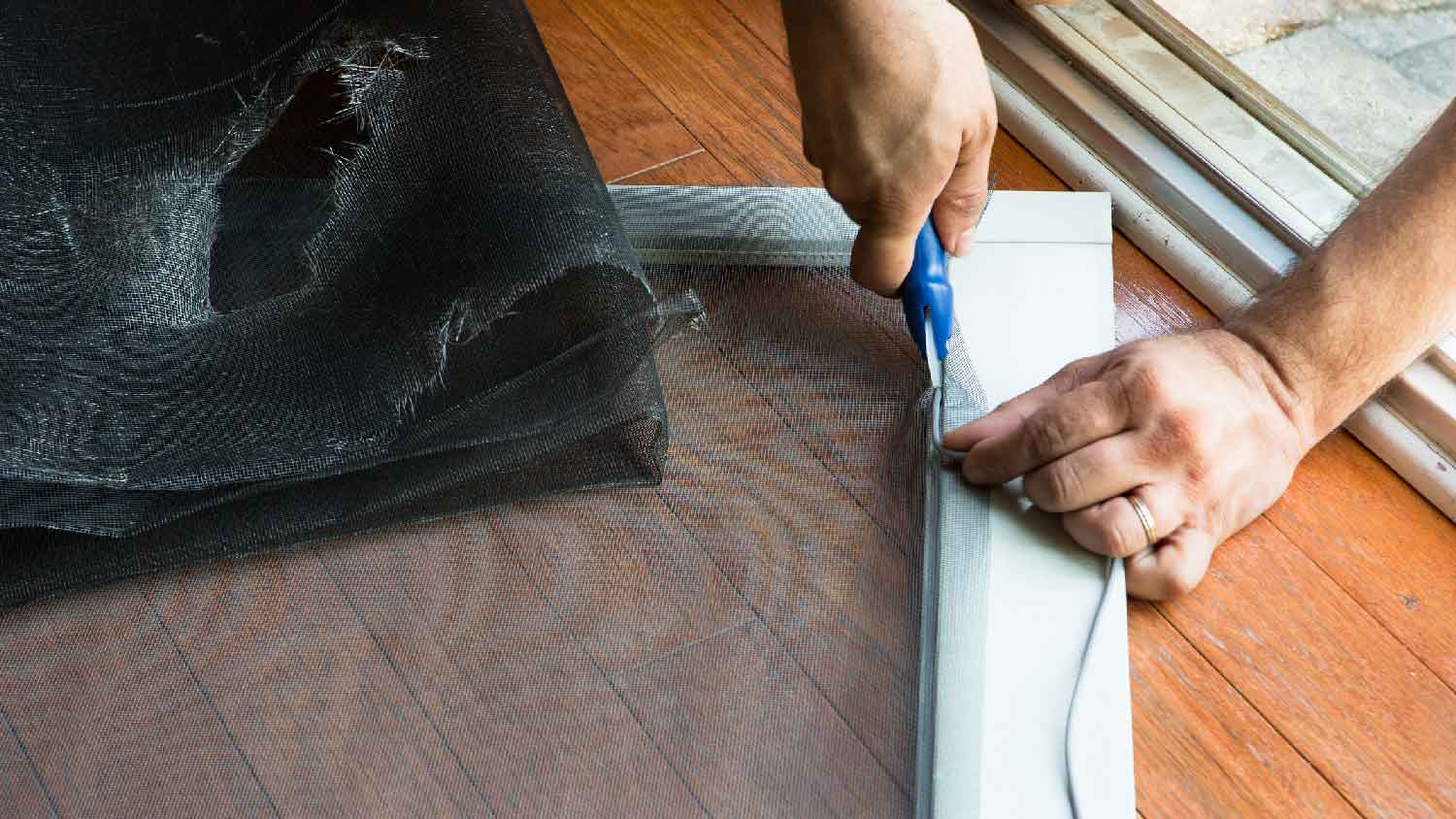 None A person fixing a screen door
