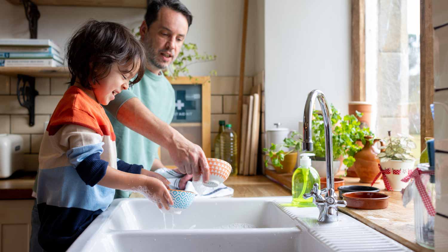 Father and son cleaning dishes