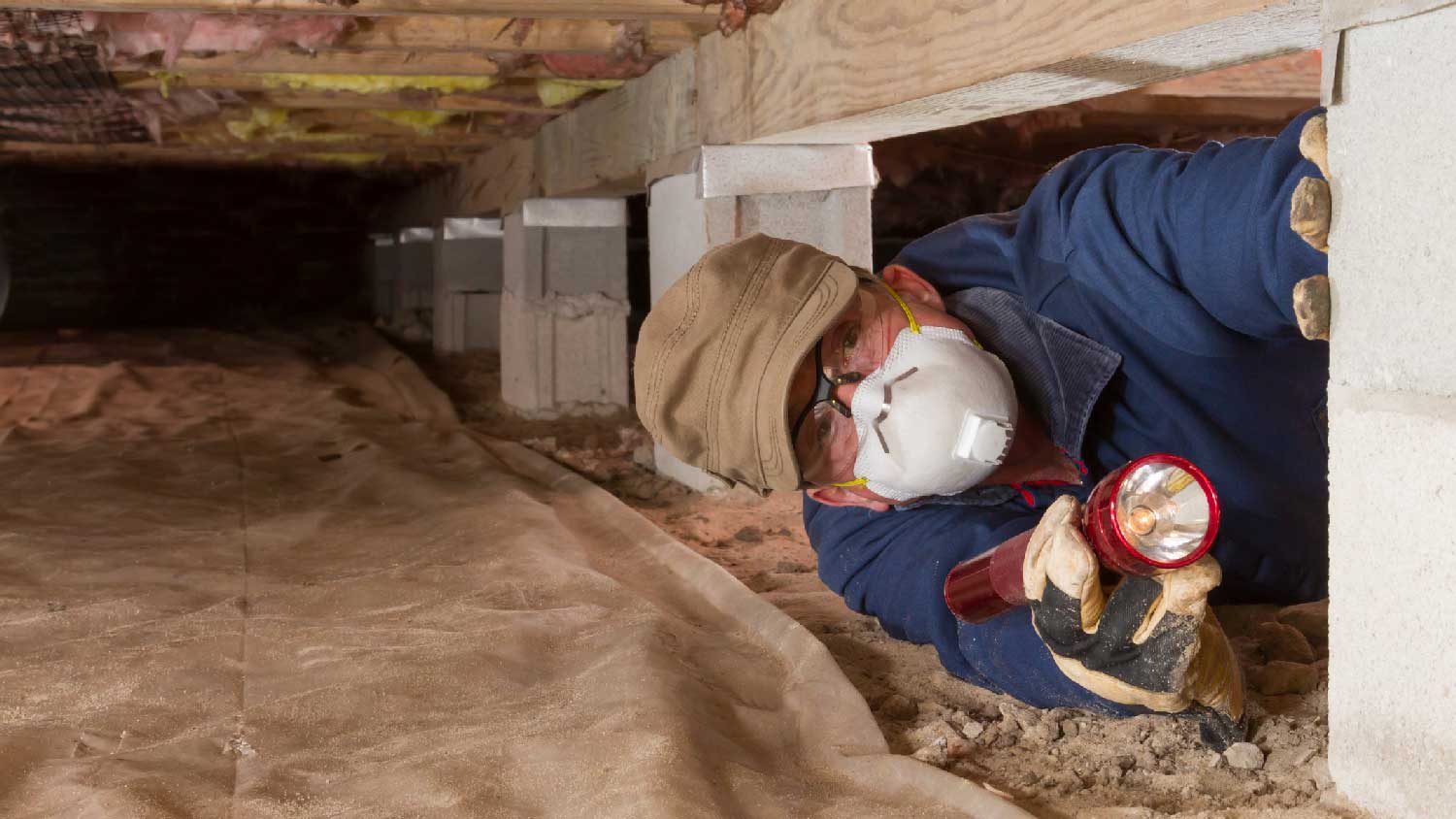 A person inspecting a crawl space
