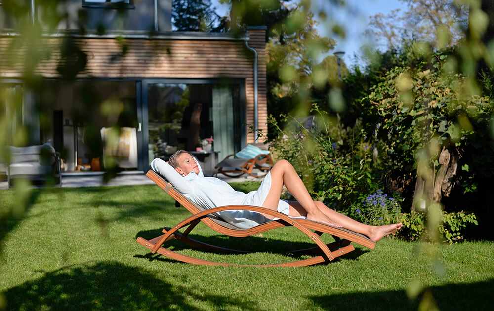 Person relaxing in backyard with turf lawn