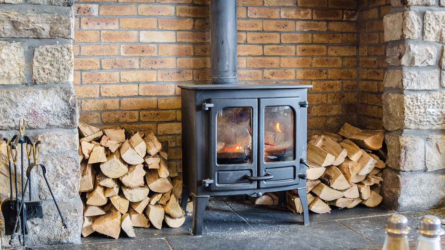 None Firewood piles sitting by a wood burning stove