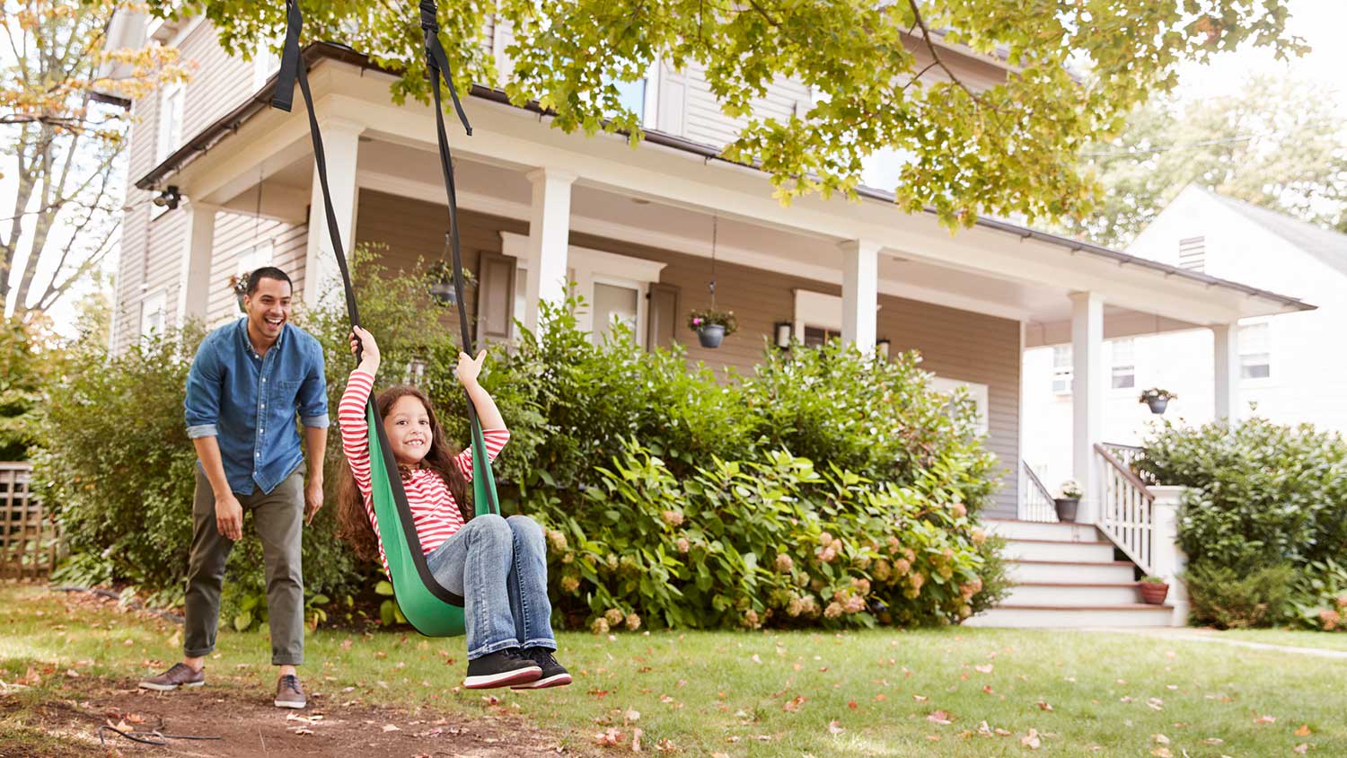 Father pushes daughter in swing
