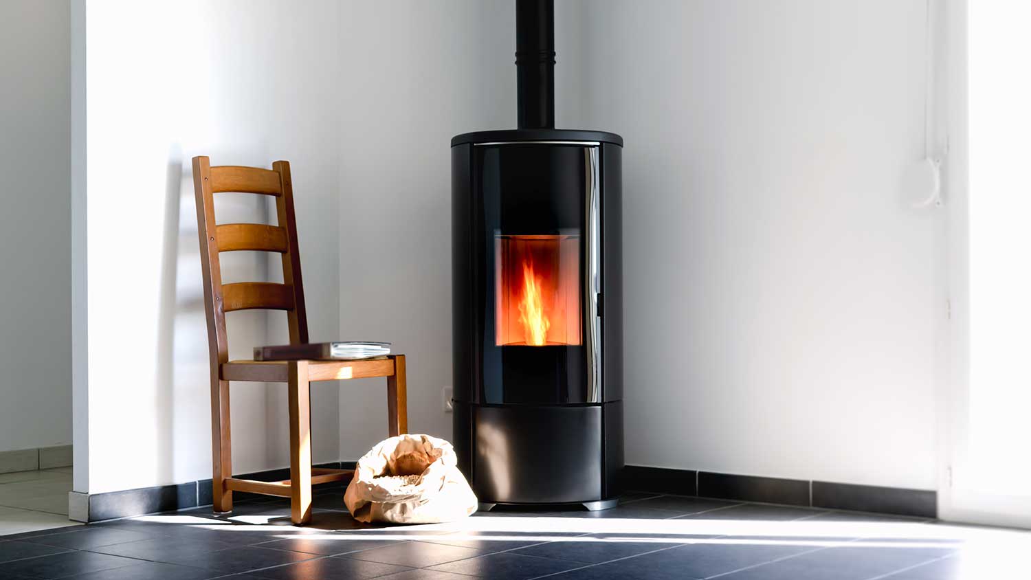 Modern pellet stove with fire burning installed in the house