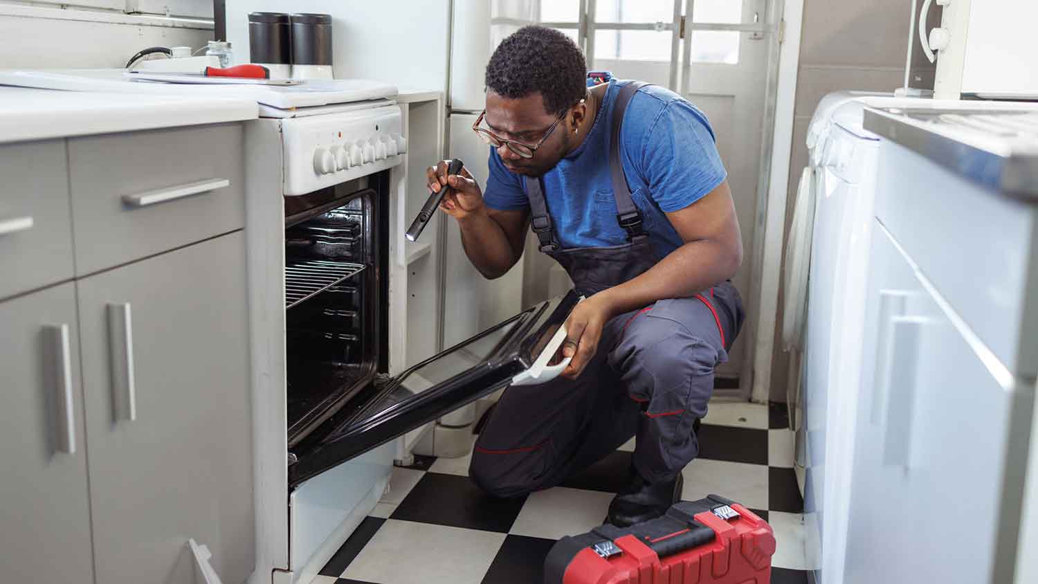 Appliance repair professional checking electric oven