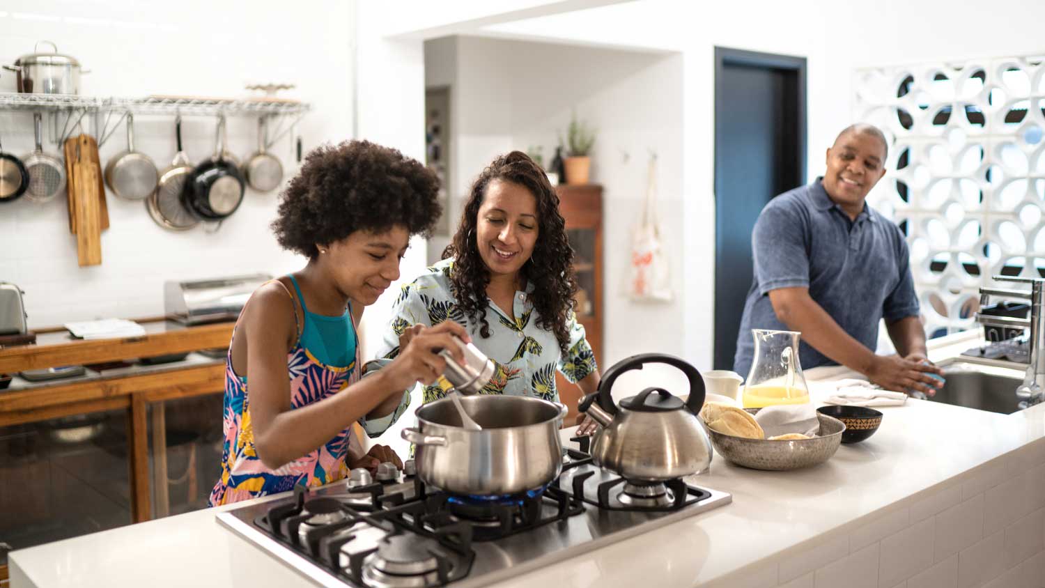 Mother teaching teenager daughter how to cook
