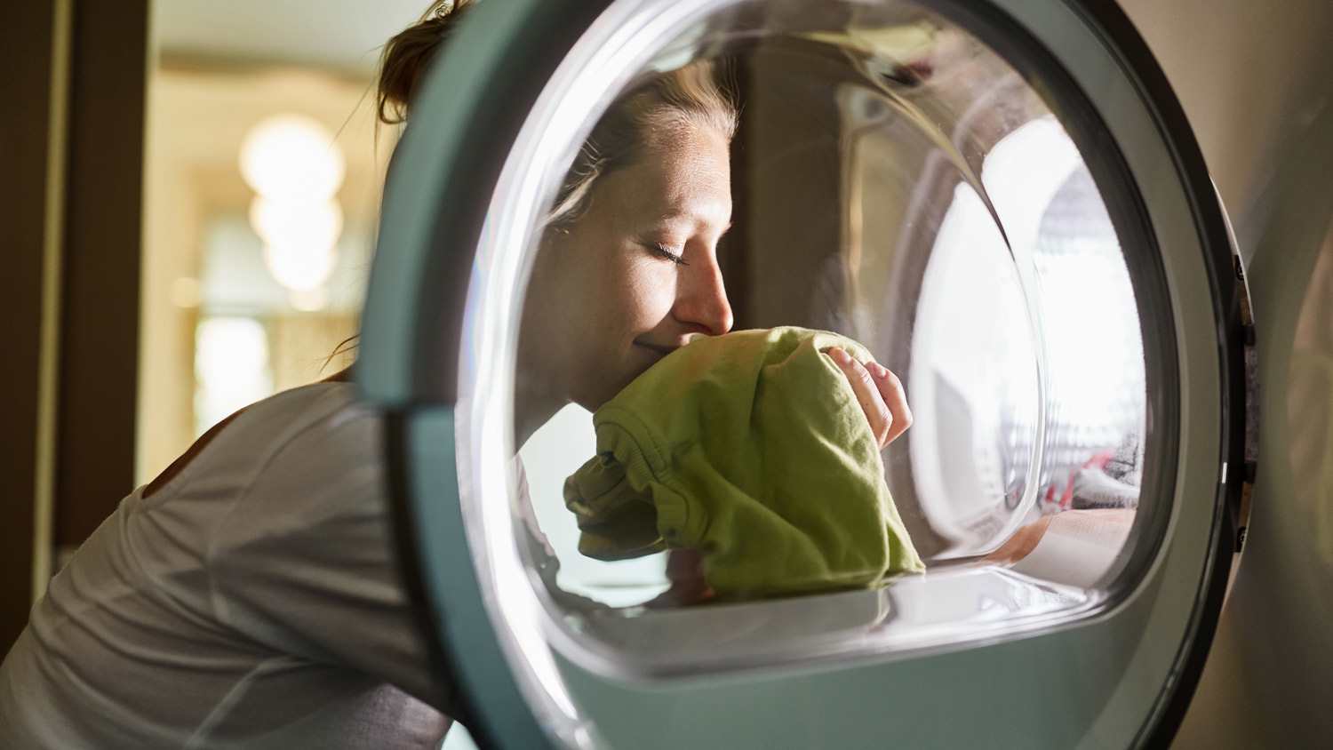 A woman smelling freshly washed clothes