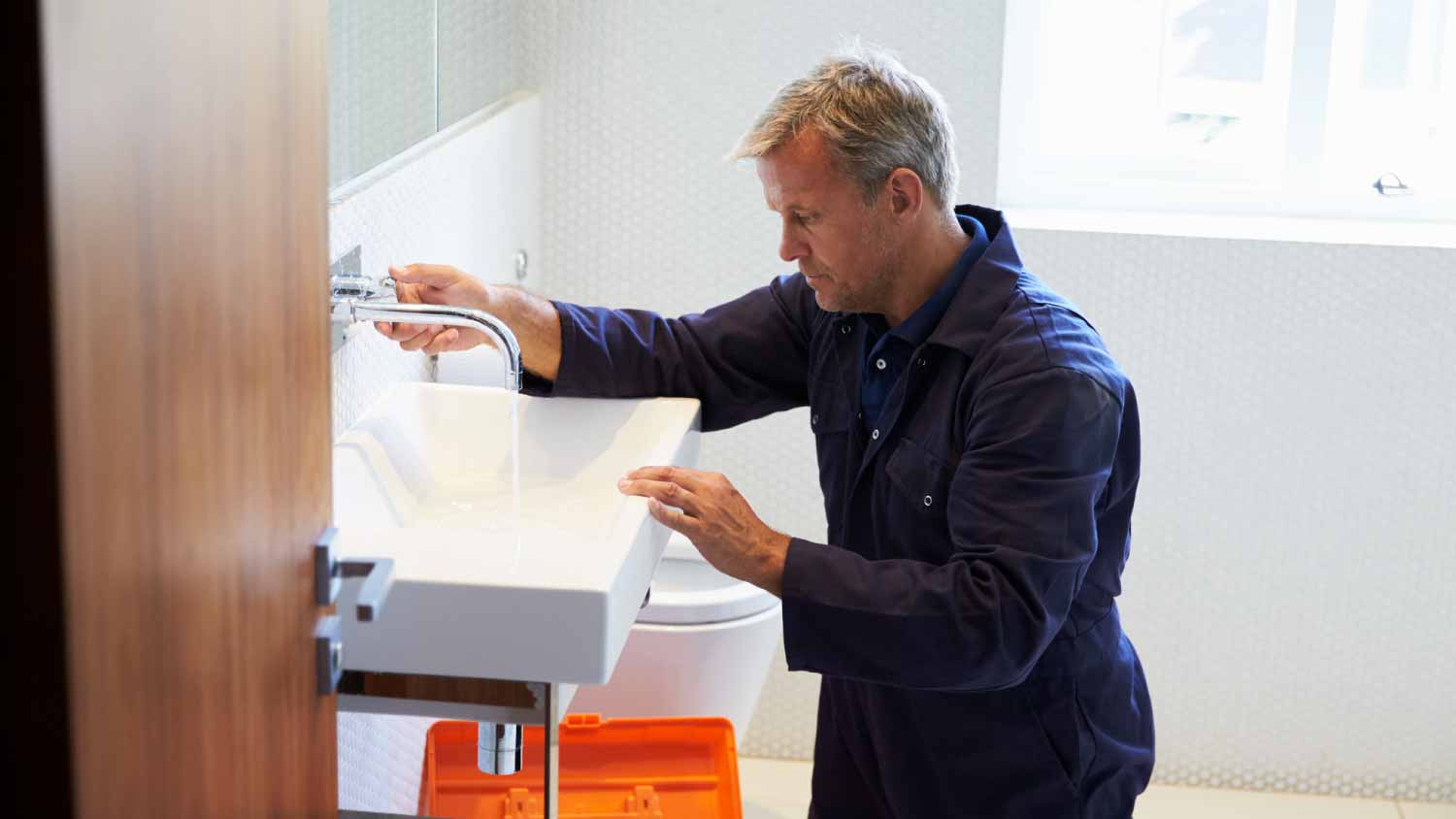 None Plumber checking sink in bathroom