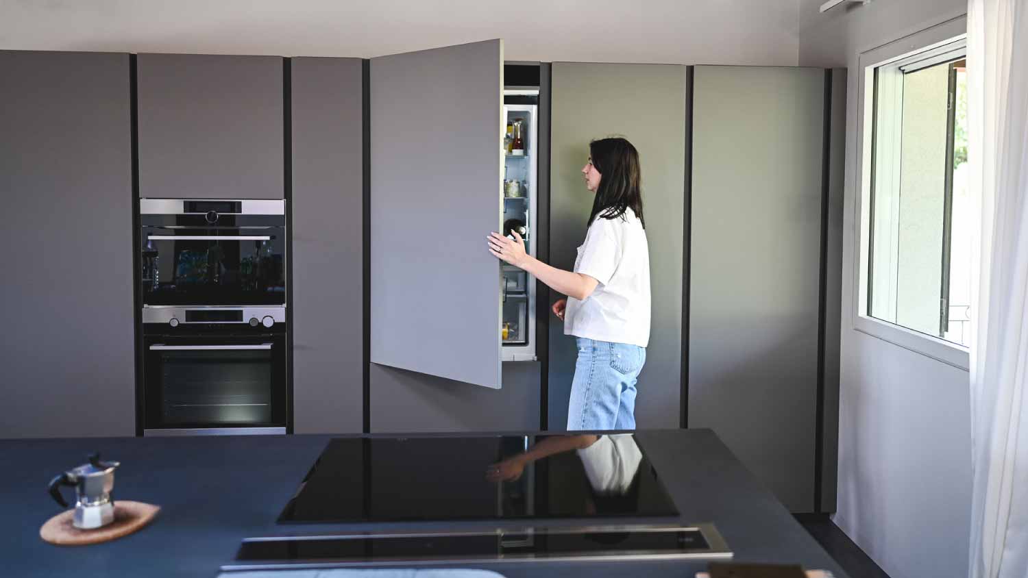 Young woman looking into fridge