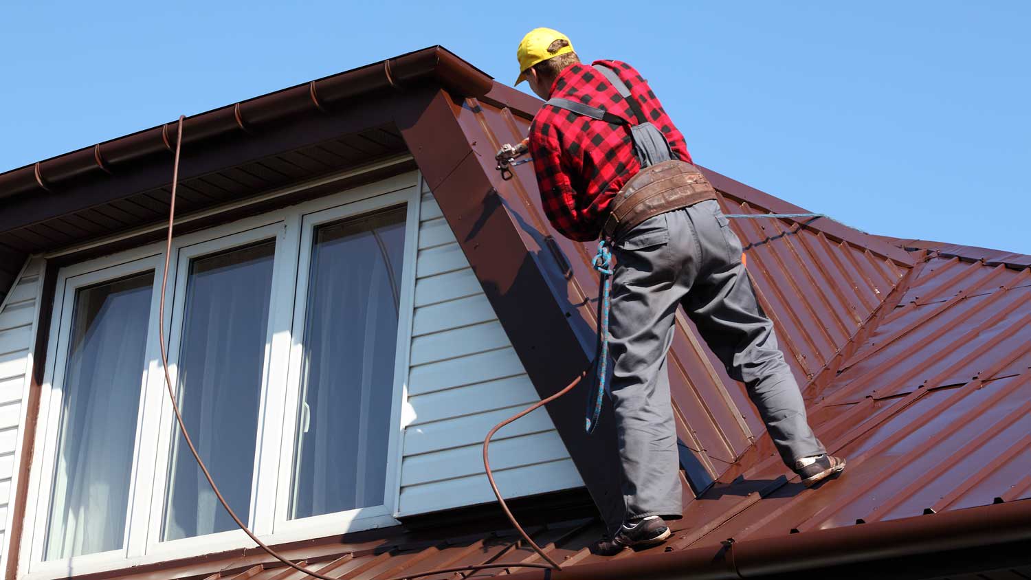 worker repairing metal roof